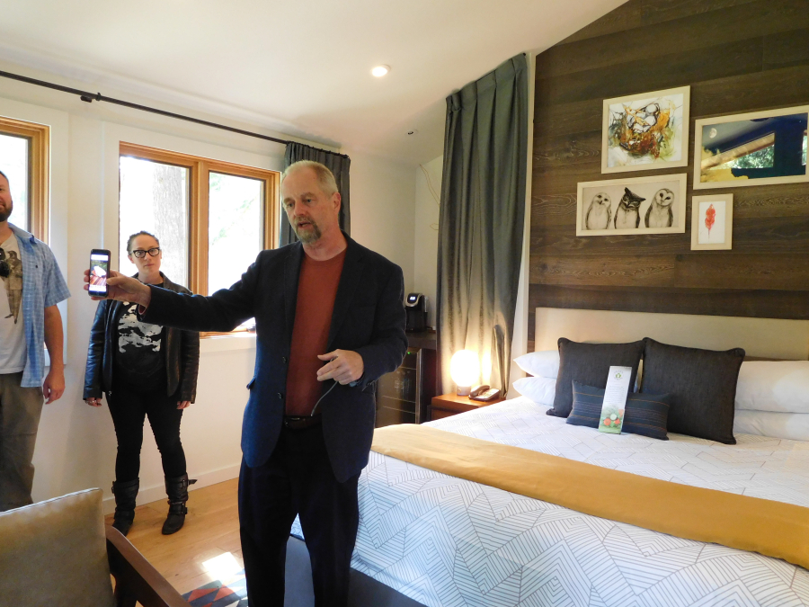 Ron Mitchell, principal architect with MG2 of Seattle, shows open house attendees a photo of an outdoor bathtub at a treehouse he built recently. The units at Skamania Lodge do not currently have this option. 