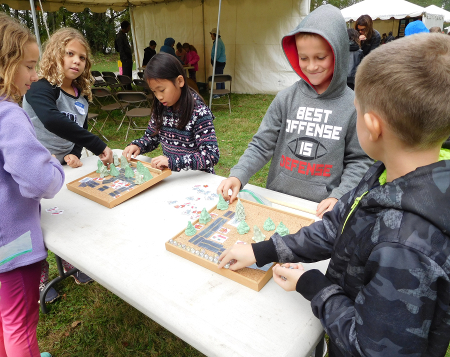 Fourth-graders from Woodburn Elementary work with a scale model of an urban watershed, where they learn the importance of trees in preventing flooding.