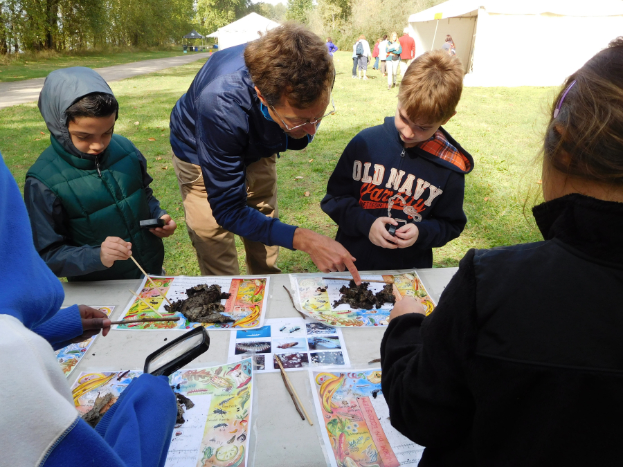 Peter DuBois, an environmental outreach specialist with Clark County Public Health, helps students spot worms in compost.