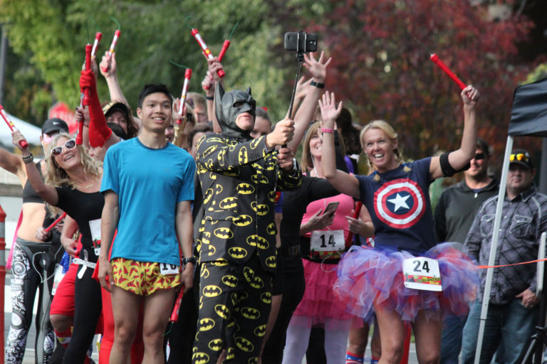 Dressed as Batman, Get Bold Events Executive Director Elba Benzler Jr. captures a selfie prior to the start of the 15K Superhero Relay on Saturday night in Washougal. Teams of three runners, dressed in hero and villain costumes, each ran a 5K leg that began at Pendleton Woolen Mills and continued along the Dike Trail. Taking home the $150 prize as the fastest team was Joe Dudman, Anthony Lee and Gary Daubenspeck, who completed the relay in 56 minutes, 54 seconds.  A team from Washougal dressed as Charlie's Angels won for best costume, an honor that was determined by crowd applause at the nearby Oktoberfest at Reflection Plaza. Benzler said plans are already in the works for next year's race, which will once again be held in conjunction with Oktoberfest. In addition to the relay, the 2017 event will also feature a Superhero Kids 1K.