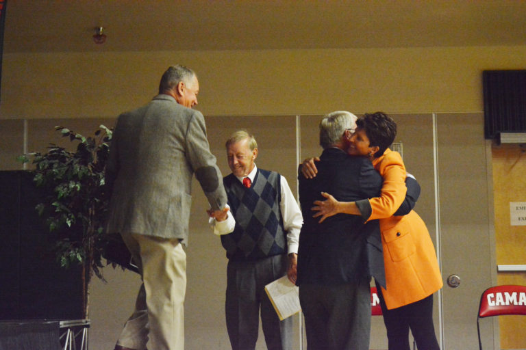 Denny Huston shakes Don Chaney's hand and Marcia Johnson hugs Pete Loop during the 2016 Camas Hall of Fame induction ceremony.