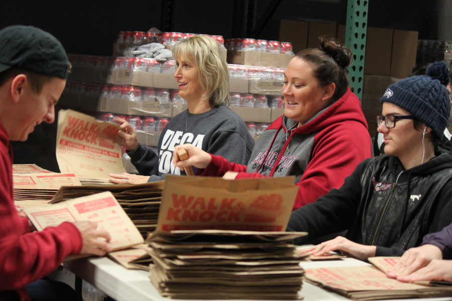 Volunteers Jacob Alvick, Shawn Perez, Christy Rice and Giovanni Nastasia (left to right) fold shopping bags on Saturday in preparation for the Clark County Walk & Knock food drive, which will be held Saturday, Dec. 3. The group from Prairie and Heritage high schools also included Delaney Shanahan,  Mallory Vanover and Tanner McDaniel (not pictured).