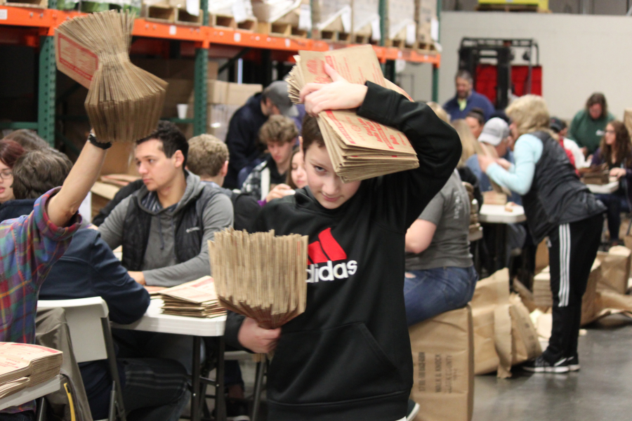 Runners collected Clark County Walk & Knock bags being folded by hundreds of volunteers at the Clark County Food Bank on Saturday morning. The bags were then stacked, ready to be transported for insertion into local newspapers. The bags will be included inside print editions of the Camas-Washougal Post-Record on Dec. 1. The bags filled with non-perishable food items will be picked up by volunteers on Saturday, Dec. 3. 