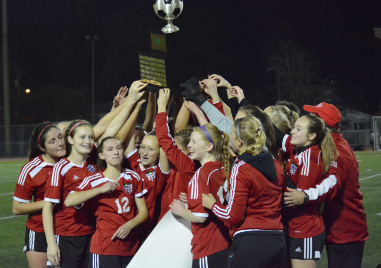 The Camas High School girls soccer players hold up the 4A state championship trophy, at Sparks Stadium in Puyallup. The Papermakers defeated West Valley, Yakima, 3-0 on Nov. 19 for their 21st victory and 20th shutout of the season.