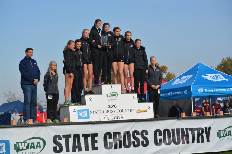 The Camas High School cross country runners and coaches stand on the podium in second place at the 4A state championship meet.