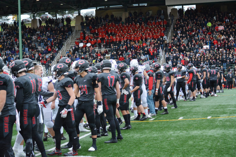 The Camas and Sumner football players shake hands at the 50-yard line at McKenzie Stadium.