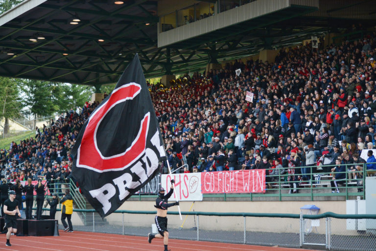 A Papermaker carries the Camas Pride flag after the football team scores a touchdown at McKenzie Stadium.