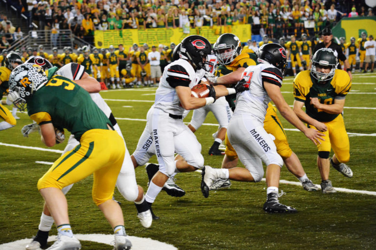 Will Schultz latches on to Jordan Howes, while three other Camas linemen clear the road.