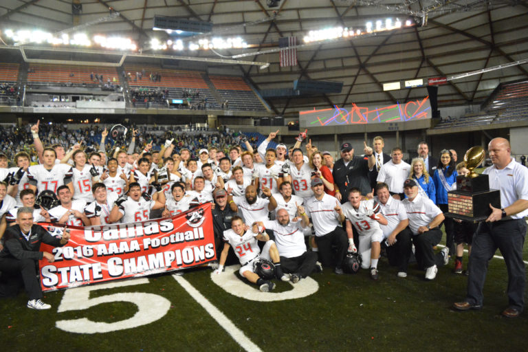 The Camas football players and coaches are presented with the state championship trophy at the Tacoma Dome.