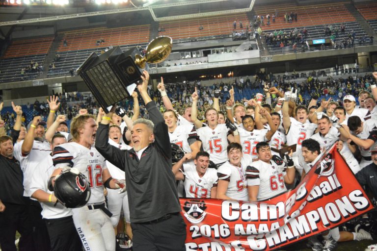 Camas High School head football coach Jon Eagle holds the trophy high as his team celebrates its 4A state championship win at the Tacoma Dome on Dec.