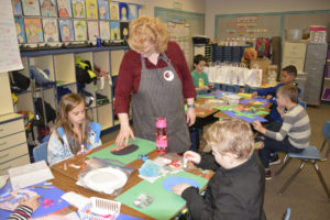 Gause artist in residence Peggy Ross assists students with the animal collage process, which took place after students researched and wrote an informational paragraph about their animal.
