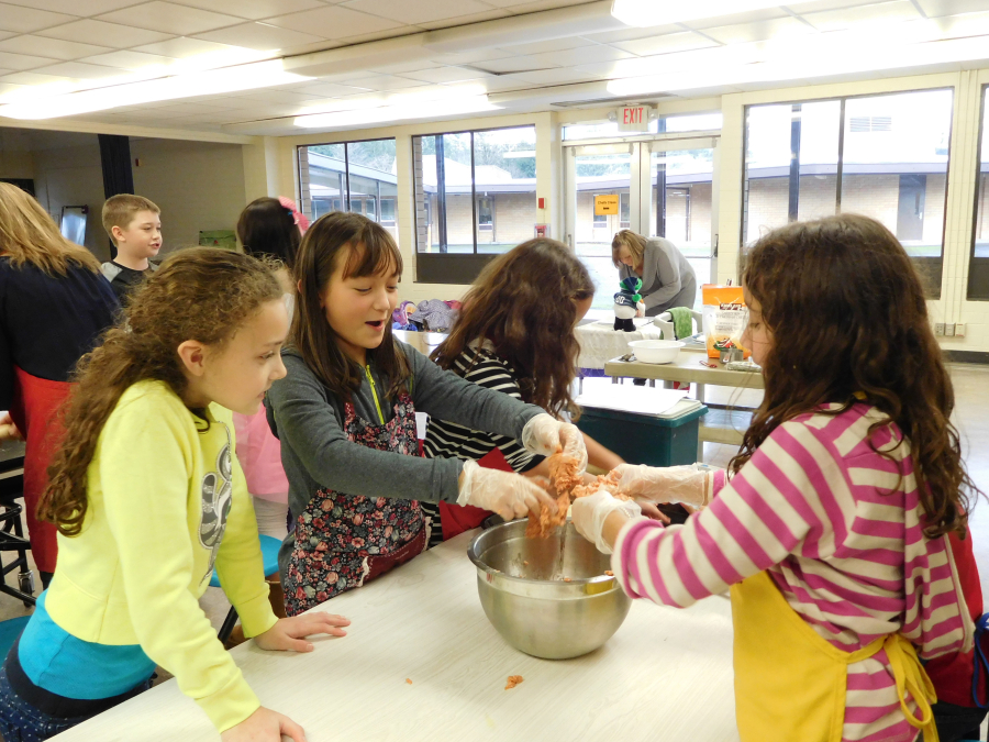 Kierra Thompson, Jasmine Bergstrom, Sophie Schuett and Helena Schuett mix spicy sausage with cheese and rosemary to make cheese balls during a "Chefs in Training," class at Camas Community Education.