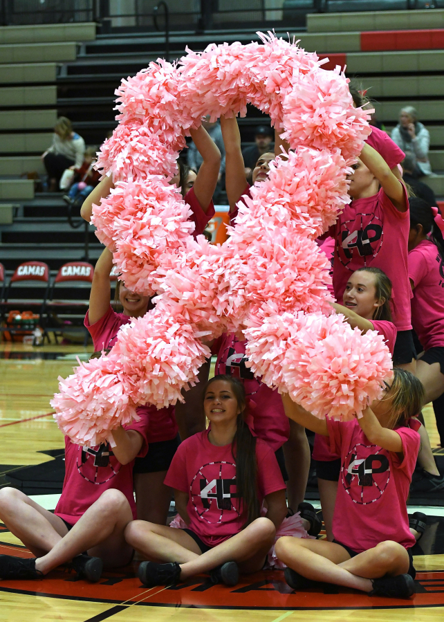 The Camas High School cheerleaders form a pink ribbon after the first quarter of Friday&#039;s game.
