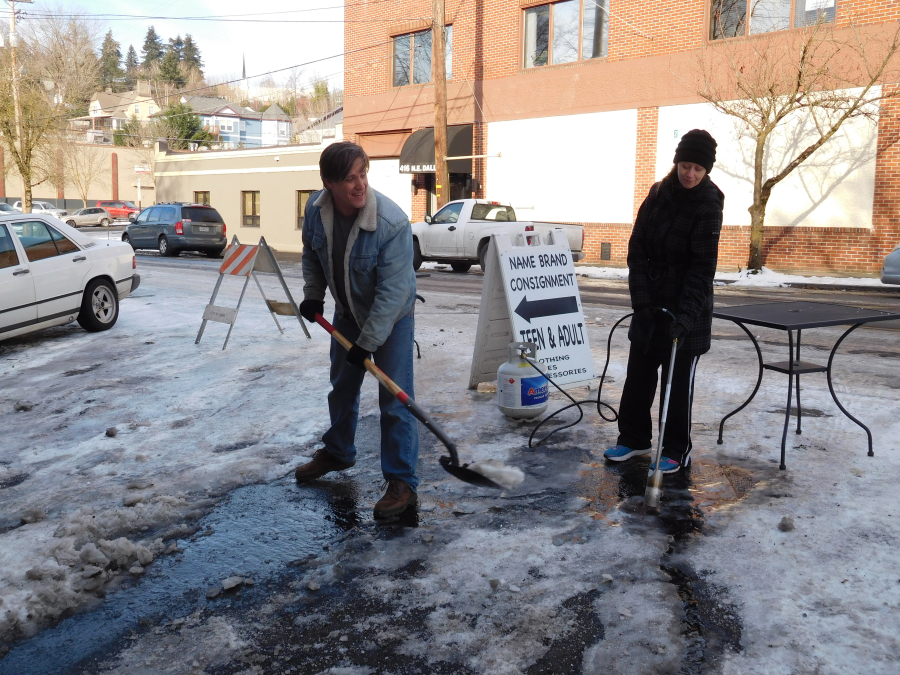Downtown Camas building owners Kyle and Stephanie Eakins use a shovel and blowtorch to remove stubborn ice from a parking spot on Northeast Dallas Street in front of Natalia's Cafe, after a car nearly slid into one of the restaurant's windows. "We want customers to come in, but we prefer that they use the front door," he joked.