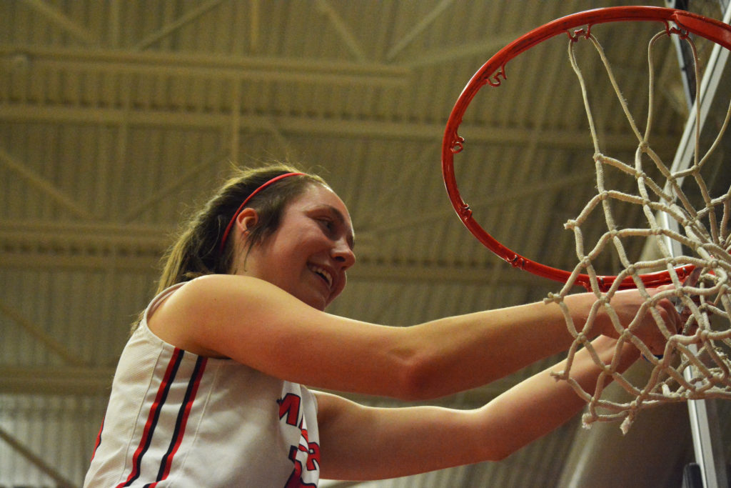 Teague Schroeder gives the basketball hoop a trimming.