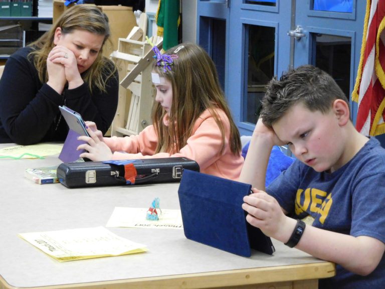 First-grade teacher Sydney Termini works with students during a recent coding club.