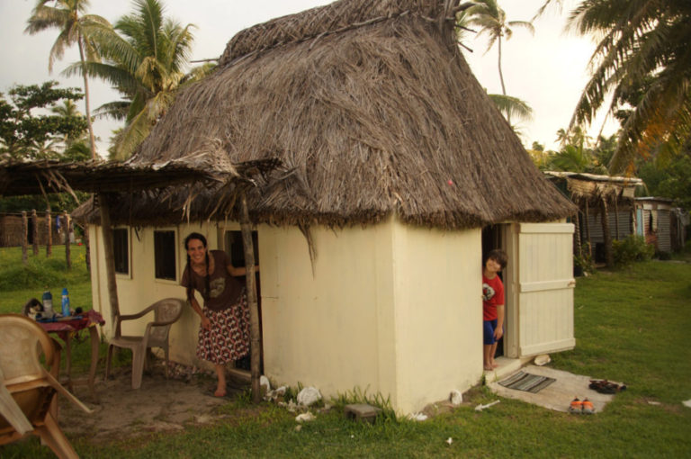 Keller and Zylus peek out from their Bure, a traditional Fijian dwelling made of wood, thatch roof, some screens and no electricity.