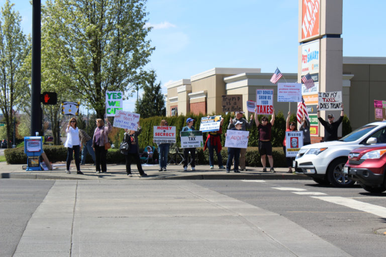 Members of the Camas Progressives group gather at the corner of 192nd Avenue and Mill Plain Boulevard in east Vancouver on Saturday afternoon, April 15, to keep pressure on President Donald Trump to return his tax information to the public.