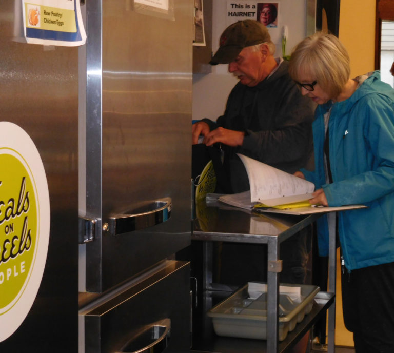 Meals on Wheels volunteer drivers at the Washougal meal site double check orders before heading out on their deliveries.