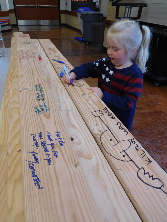 Elsie Martin, 4, of Vancouver, drew a flower on a board that will be part of the new home for Alex and Kim Hussey. Martin&#039;s father, Zack, is an engineering manager at MacKay Sposito, a Vancouver firm that has donated engineering services for two Homes For Our Troops houses.