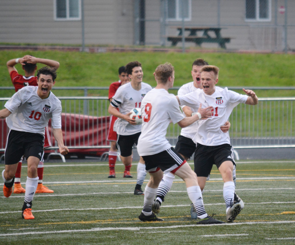 Josh Tkachenko (21) celebrates with his teammates after scoring a golden goal for Camas in the final minute of double overtime Tuesday, at Doc Harris Stadium. The Papermakers beat Sunnyside, of Yakima County, 4-3 in the first round of the state tournament.