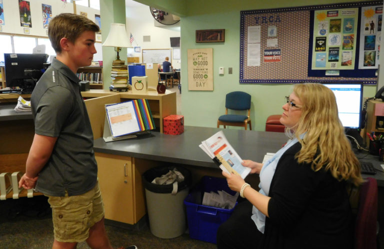 Jacob Warta, a second-year reporter, chats with teacher Emily Crawford about the upcoming issue of The Monthly Roar.  Warta decided to give journalism a chance after a disappointing experience with yearbook class in the sixth grade.
