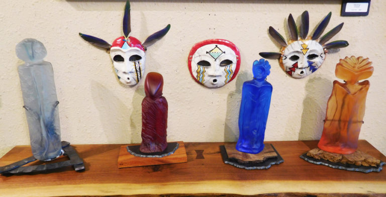 These raku clay masks and glass sculptures are for sale at the Camas Gallery.