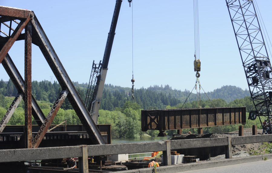 Workers remove pieces of the old Washougal River BNSF Railway bridge in Camas on Monday, June 5. The rail company estimates it will be another two months before the bridge will be back in production. The new, wider-clearance, truss bridge replaces a 110-year-old crossing.