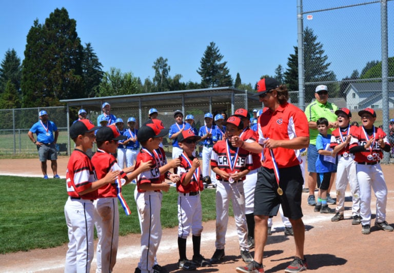The Camas Little League 9- to 10-year-old baseball all-stars and coaches collect their medals after beating Cascade 10-3 in the District 4 Championship game Sunday, at George Schmid Memorial Park, in Washougal.