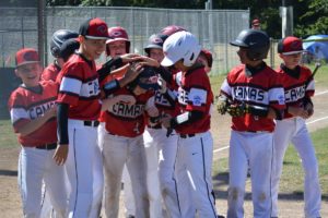 Jackson Knuth gets congratulatory pats from his teammates at home plate after hitting a 3-run home run for Camas Little League Sunday, at David Douglas Park in Vancouver. 