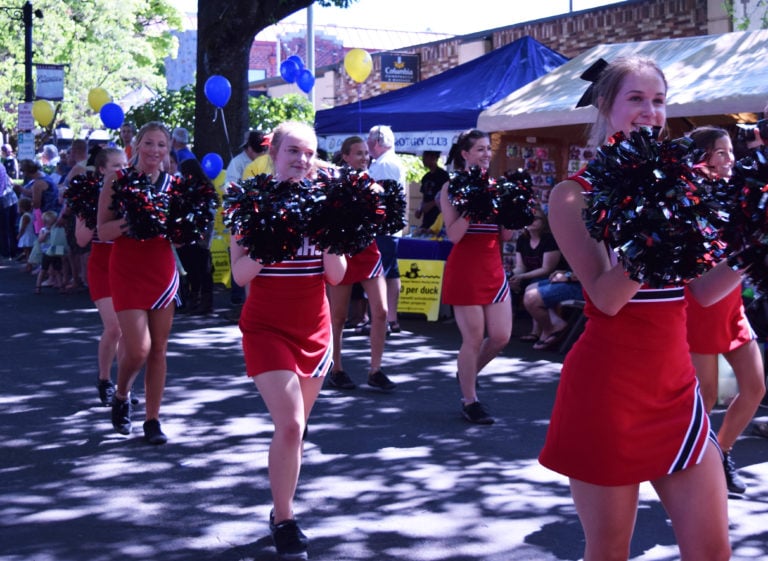 The Camas High School cheerleaders rally down Fourth avenue during the parade on Saturday.