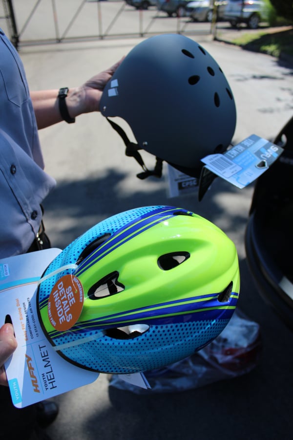 Tami Strunk, code enforcement officer for the city of Camas, holds two styles of bike helmets that she recently picked up to give away to youth in need this summer. The Camas Police Department used an anonymous $2,000 donation to buy about 120 helmets in a variety of styles, colors and sizes.