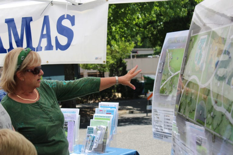 Volunteer Bobbie White, of Camas, shows two possible options for a Crown Park and Pool upgrade to visitors who wandered into the city of Camas&#039; booth at last weekend&#039;s 43rd annual Camas Days celebration. Consultants from the Portland-based Greenworks PC, hired by the city of Camas earlier this year to help plan the future of Camas&#039; Crown Park and Pool, surveyed community members this spring and received 1,400 comments about the beloved park and its 63-year-old pool -- the only public outdoor swimming pool in Clark County. The options the consultants came up with are the result of these 1,400 comments. The public can weigh in on the options online until Friday, Aug. 4, at www.ci.camas.wa.us.