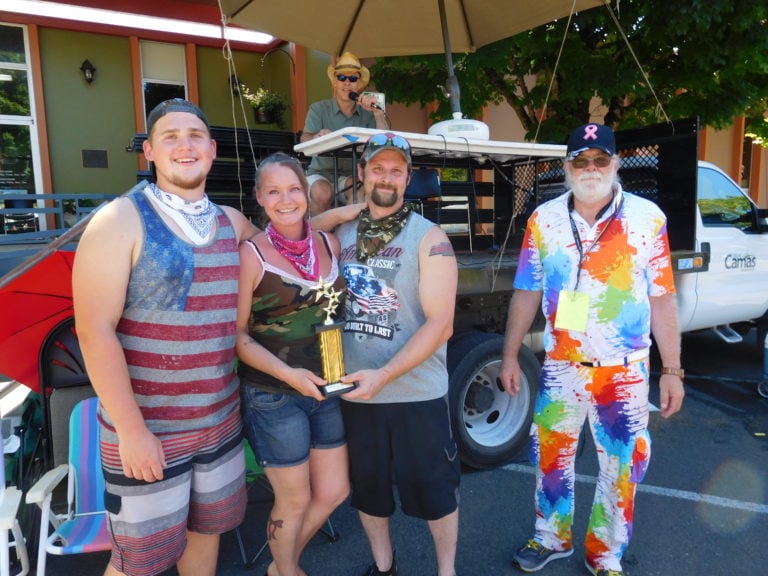 The "Bathtub Bandits" claimed first place in the Bathtub Races at Camas Days, Saturday, on Northeast Fourth Avenue. The team featured Triston Groth, Tanya Groth and Greg Irwin (left to right). Race Coordinator Pat Ray, of California (right), presented them with the trophy.  Doug Quinn (background) has announced the bathtub races for two decades. 