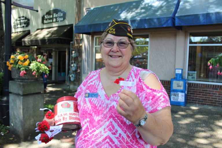 Evelyn Thompson, a veteran of Desert Storm who served in the United States Navy on the USS Acadia and member of the VFW 4278, hands out red poppies to remember fallen World War I veterans on Friday, July 21, at the 43rd annual Camas Days celebration in downtown Camas.