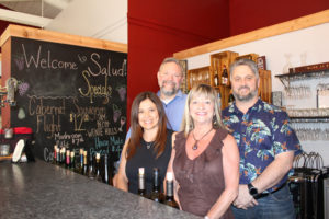 The owners of Camas’ newest business, the Salud! wine bar, wine storage facility and events center, gather behind the bar on July 31, a few days before Salud!’s grand opening. Pictured clockwise from the front-left are: Yolanda Taylor, Gerald Taylor, Tony Dotson and Raechill Dotson. 