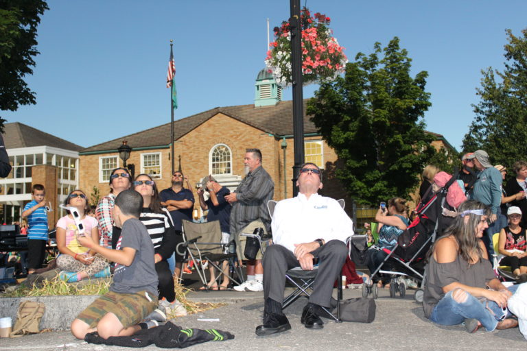Camas City Manager Pete Capell (center, in white shirt) watches the historic solar eclipse near Camas City Hall on Monday, Aug. 21. Photo by Kelly Moyer/Post-Record