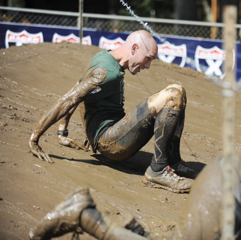 Robert Killian crawls through the barbed wire section Saturday.