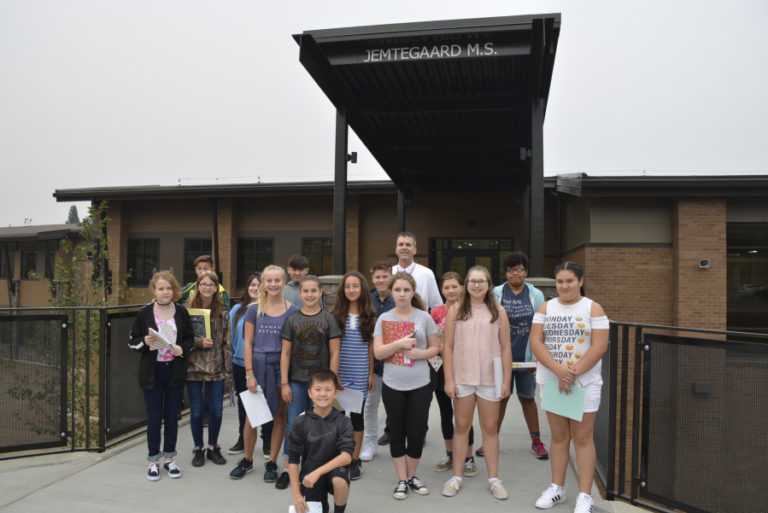 Students gather outside of the new building with principal David Cooke (background).