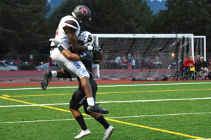 Ja'Michael Shelton hangs on to the football, while getting tangled up with a defender, Friday, in Sherwood, Oregon. Shelton landed on his feet and scored a 44-yard touchdown for Camas. The Papermakers beat the Bowmen 34-12. (Contributed photo by Kris Cavin)