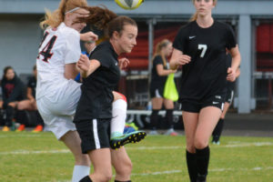 Sydney Mederos (center) fights for possession of the soccer ball Sept. 21, at Longview Memorial Stadium. The Washougal High School senior delivered the winning shootout goal for the Panthers against Ridgefield on Sept. 19. 