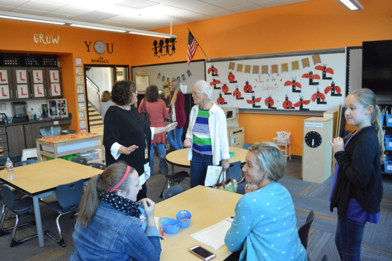 Emily Higley (bottom left) and Carly Hack enjoy conversations with guests visiting their pre-school room during the Oct.