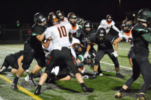The Washougal football team tries to stop Woodland running back Tyler Flanagan from getting a first down Friday, at Woodland High School. The Beavers beat the Panthers 20-7. 