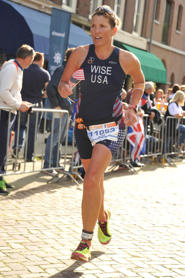 Alisa Wise holds an American flag as she gets close to finishing the World Triathlon Grand Final Sept. 17, in Rotterdam, Netherlands.