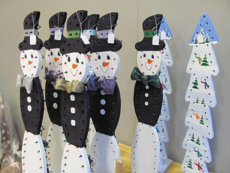 Hand-carved snowmen, with holiday lights attached, top a table at a past Washougal High School bazaar.