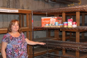 Renee Law, 55, coordinator of the Children’s Home Society of Washington’s East County Family Resource Center, stands in the Washougal center's nearly bare food pantry. The center needs food donations to help local families in need and to help fill its backpack programs, which assists about 60 Washougal area students. (Photo by Tori Benavente/Post-Record)