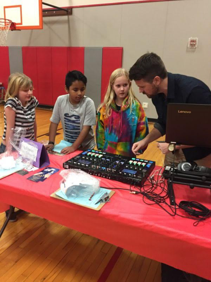 Music producer Kyle Devine shows Hathaway Elementary School students how to use sound equipment at the Dream Big event, held Dec. 6. Devine, who also is a parent volunteer, says events like Dream Big inspire young students.