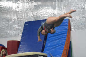Camas head coach Carol Willson (left) watches team captain Joy Marsh swirl through the air off the vault at Naydenov Gymnastics Center, in Vancouver. Marsh returns from a dislocated shoulder injury to help the Papermakers build on their second place finish at state last season. 