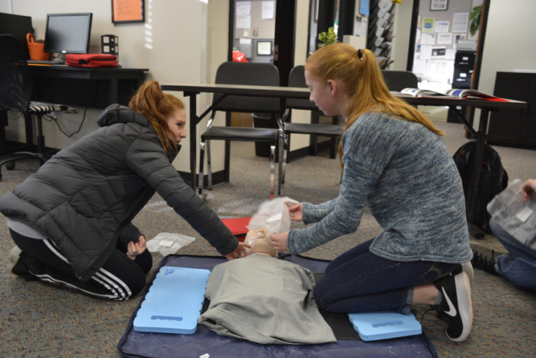 Washougal High students Lexi Sneer (left) and Ellie Watts (right) learn CPR skills during a recent CPR and first aid certification course.