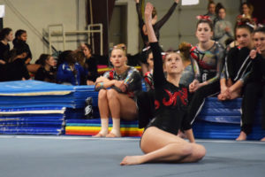 Abigail Martin, Camas High School sophomore, performs her floor routine as the CHS gymnastics team cheers her on during a meet at Northpointe Gymnastics on Friday, Jan. 12. 